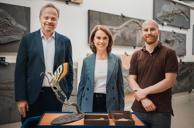 Prof. Dr. Lars Krogmann, Ministerin Petra Olschowski und Dr. Stephan Spiekman (von links nach rechts) vor einem Modell von Mirasaura.