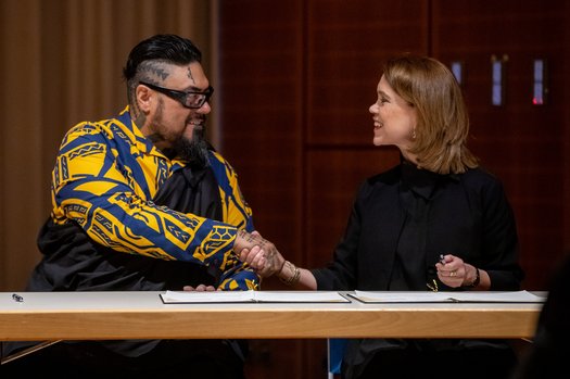 Zwei sich die Hände schüttelnde Personen bei der Rückgabezeremonie