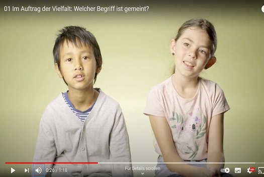 Zwei sitzende Kinder sprechen.