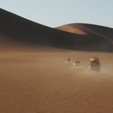 Mehrere Autos fahren durch eine Wüste