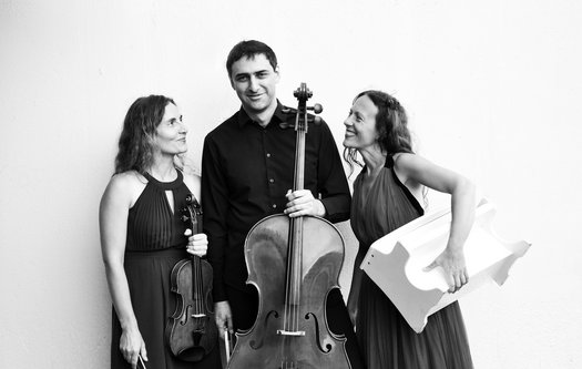 Schwarz-Weiß-Aufnahme von drei Menschen mit Musikinstrumenten in der Hand