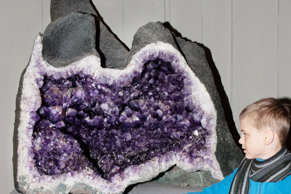 Kind neben großer Amethyst Druse