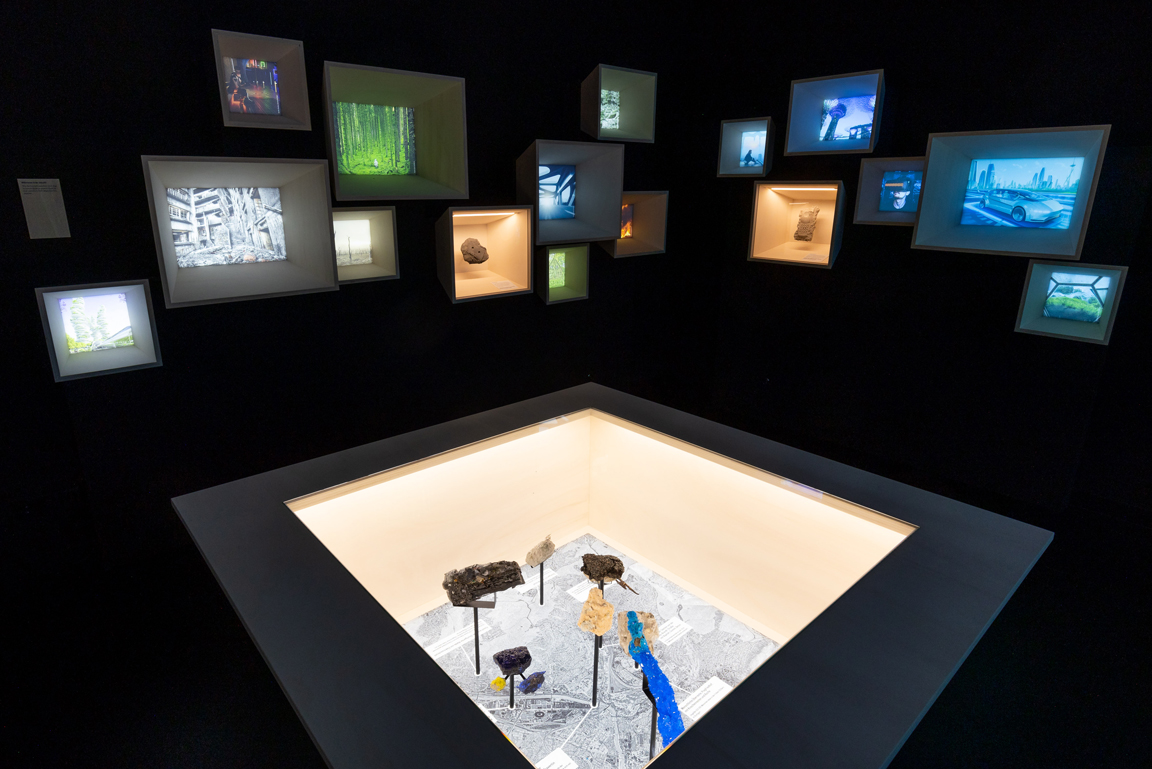 Vitrinen mit Bildern und Kunstobjekten in der Sonderausstellung Anthropozän.
