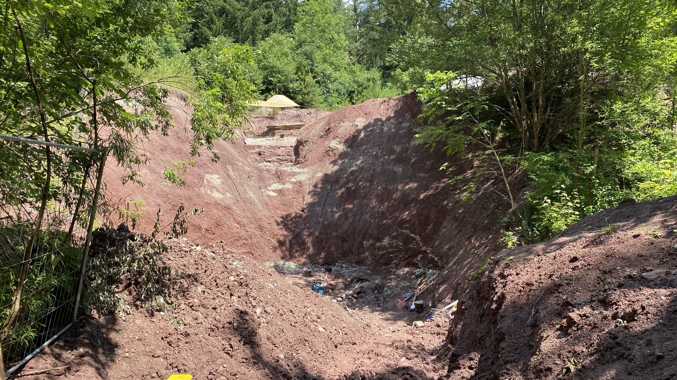 Blick auf die Grabungsstelle, bestehend aus rotem Gestein