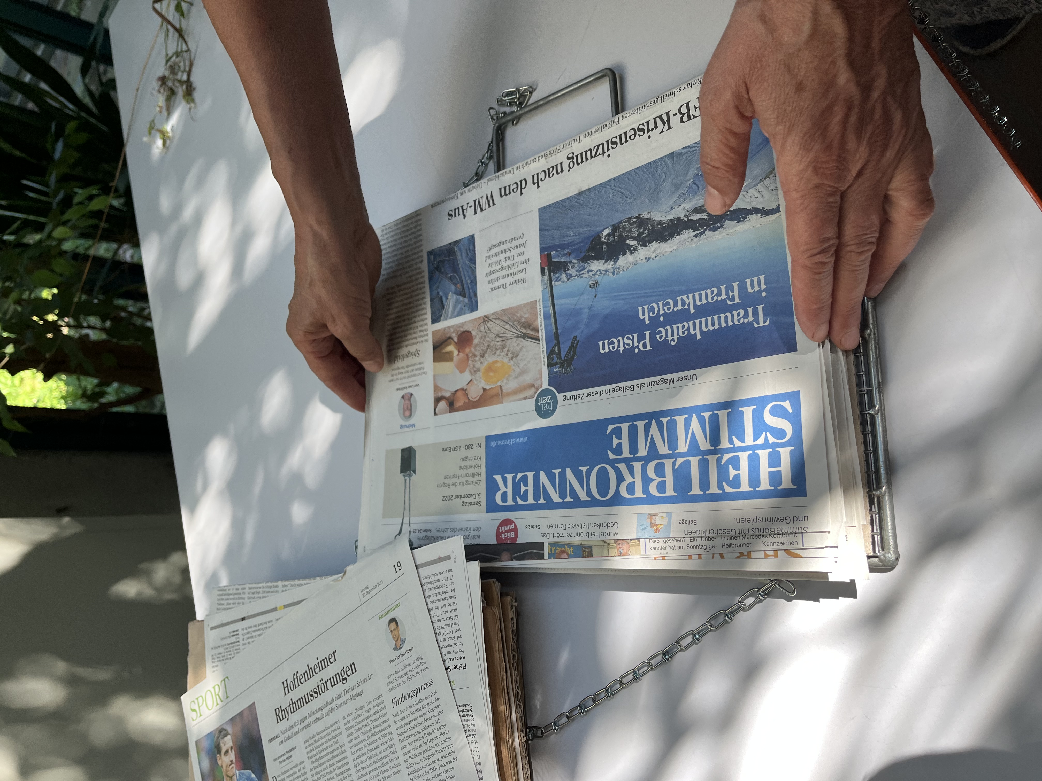 In eine Pflanzenpresse aus Metall werden zusätzliche Zeitungsblätter als saugfähige Schicht gelegt.