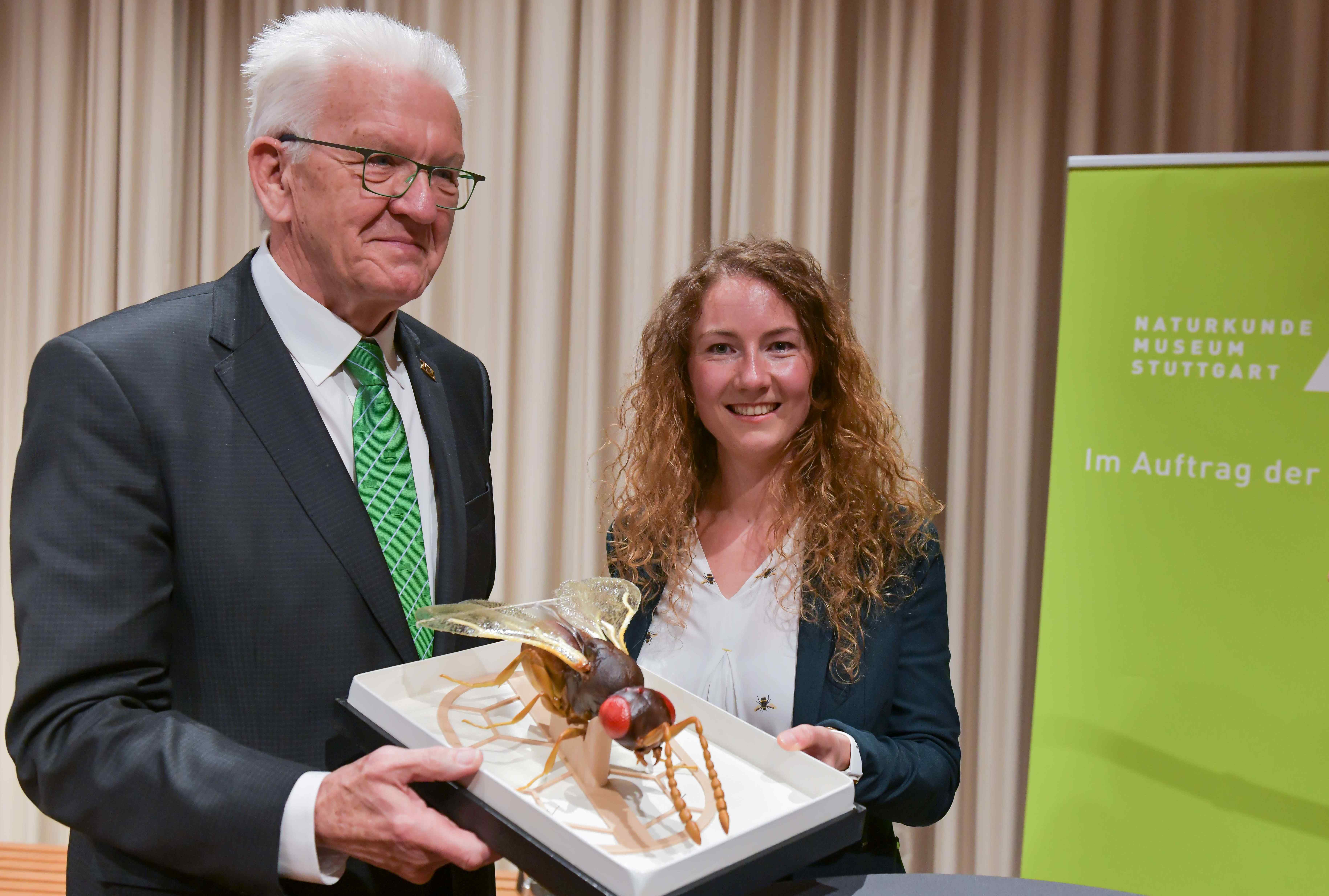 Ministerpraesident Kretschmann und Marina Moser mit Modell der Wespe Aphanogmus kretschmanni