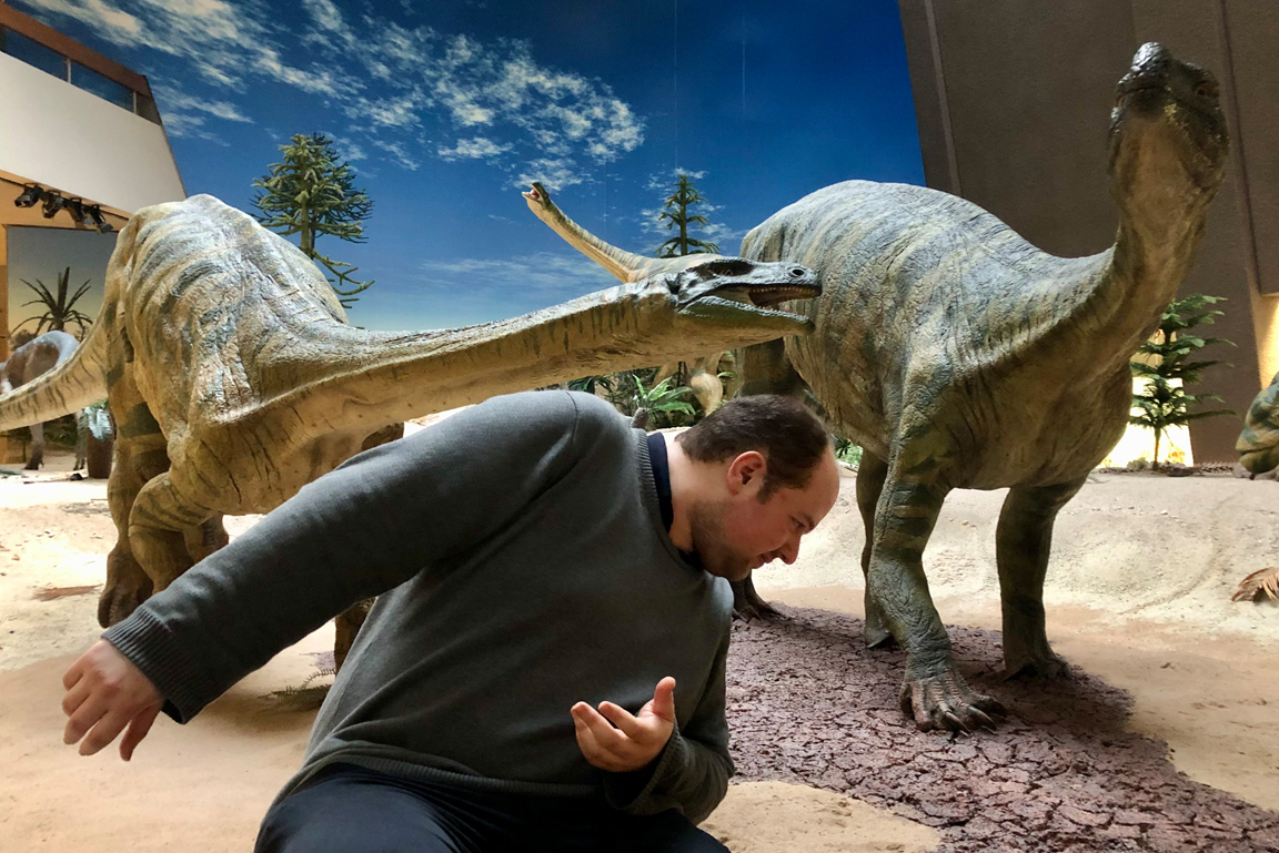 Diorama mit Plateosauriermodellen, davor ein Mann.