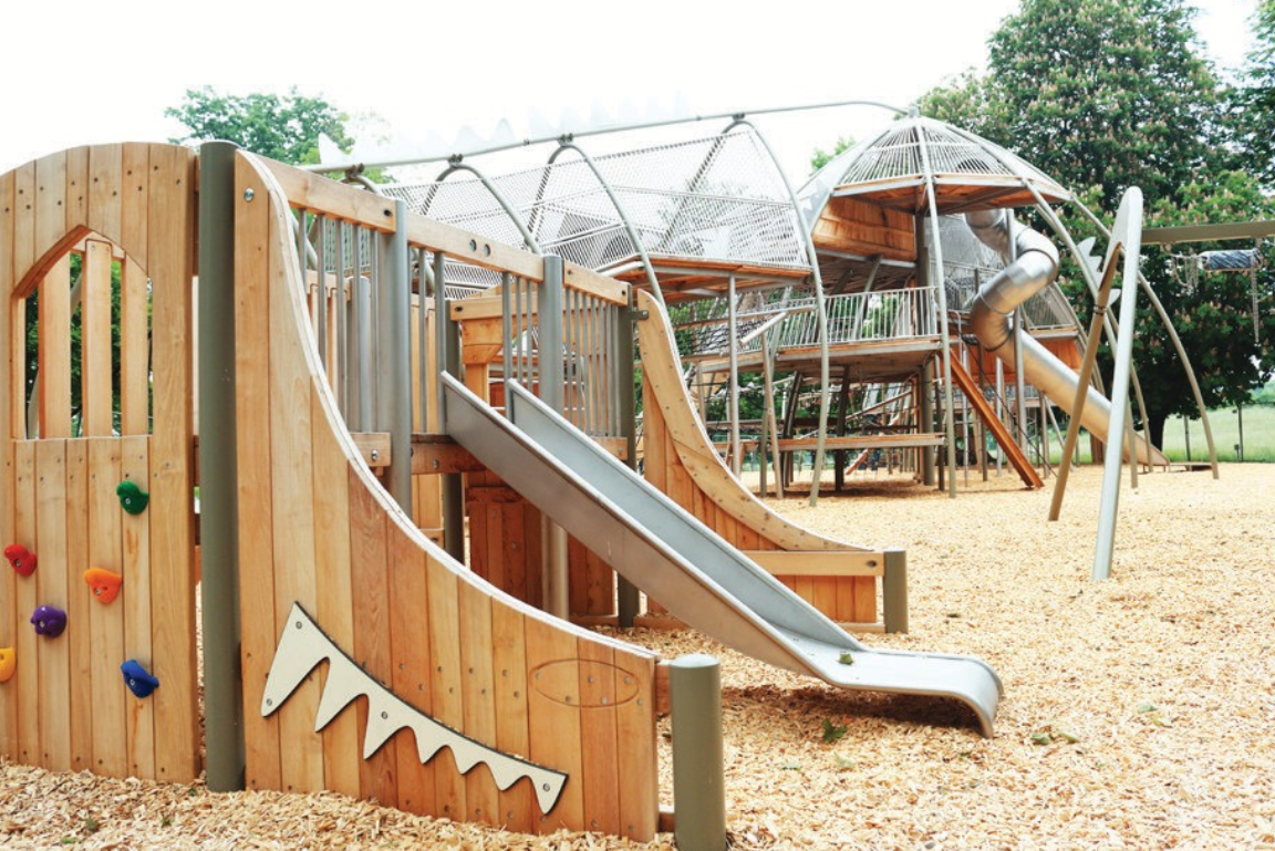 neu gestalteter Spielplatz im Rosensteinpark. Vordergrund eine Rutsche im Hintergrund großer Kletterdino